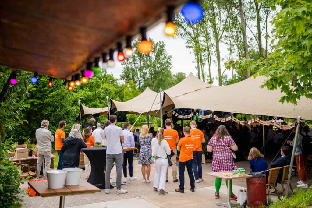bedrijfsfestival-congrestival-10 Event met kleurrijke verlichting en mensen in teamverband rondom een podium – een voorbeeld van inspirerende locaties in Nederland, verrassend centraal gelegen met voldoende zalen en directe beschikbaarheid.